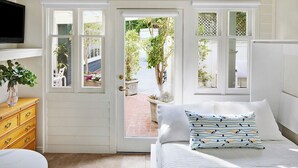 A bedroom with a bed, a dresser, and a TV mounted on the wall. - Channel Road Inn, A Four Sisters Inn (Santa Monica)