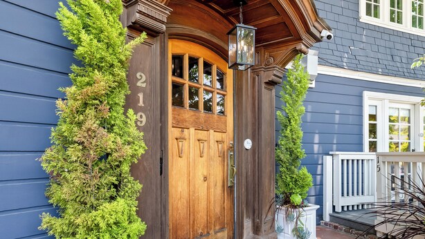 A wooden front door with a number "219" above it, flanked by two potted plants. - Channel Road Inn, A Four Sisters Inn (Santa Monica)