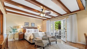 A spacious bedroom with a large bed, two armchairs, a wooden ceiling, and a view of the outdoors. - Channel Road Inn, A Four Sisters Inn (Santa Monica)
