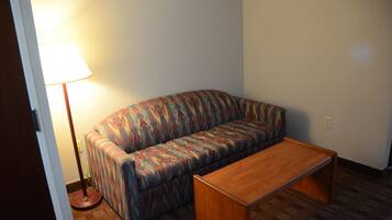 A room with a sofa and a wooden coffee table.