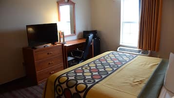 A hotel room with a bed, a desk, a television, a chair, a dresser, a mirror, and a window with curtains.