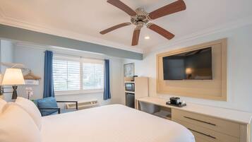 Relax in this spacious room featuring a large bed, flat-screen TV, and kitchenette.