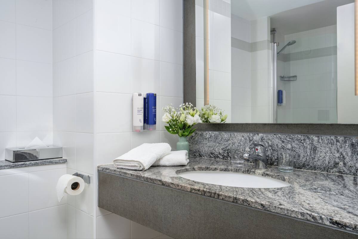 combined shower/bathtub, designer toiletries, hair dryer, slippers