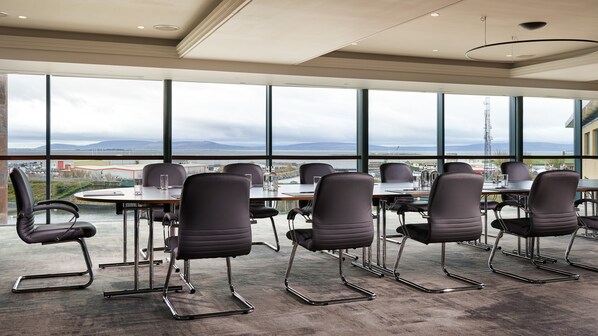Un salón de conferencias con vistas a la ciudad y a las montañas.