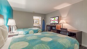 A hotel room with two beds, a TV, a desk, and a bathroom visible through an open door. - Carolina Lodge (Barnwell)