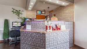 A reception area with a reception desk, computer, and framed certificates on the wall. - Carolina Lodge (Barnwell)