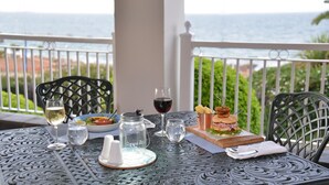 A table set with a meal, drinks, and a view of the sea. - Courtyard Hotel Gqeberha (Gqeberha (Port Elizabeth))