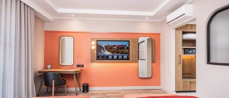 A hotel room with two beds, a desk, a chair, a TV, and a wardrobe.