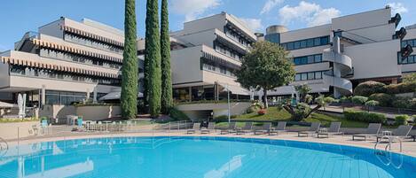 Piscina a l'aire lliure de temporada, para-sols i gandules
