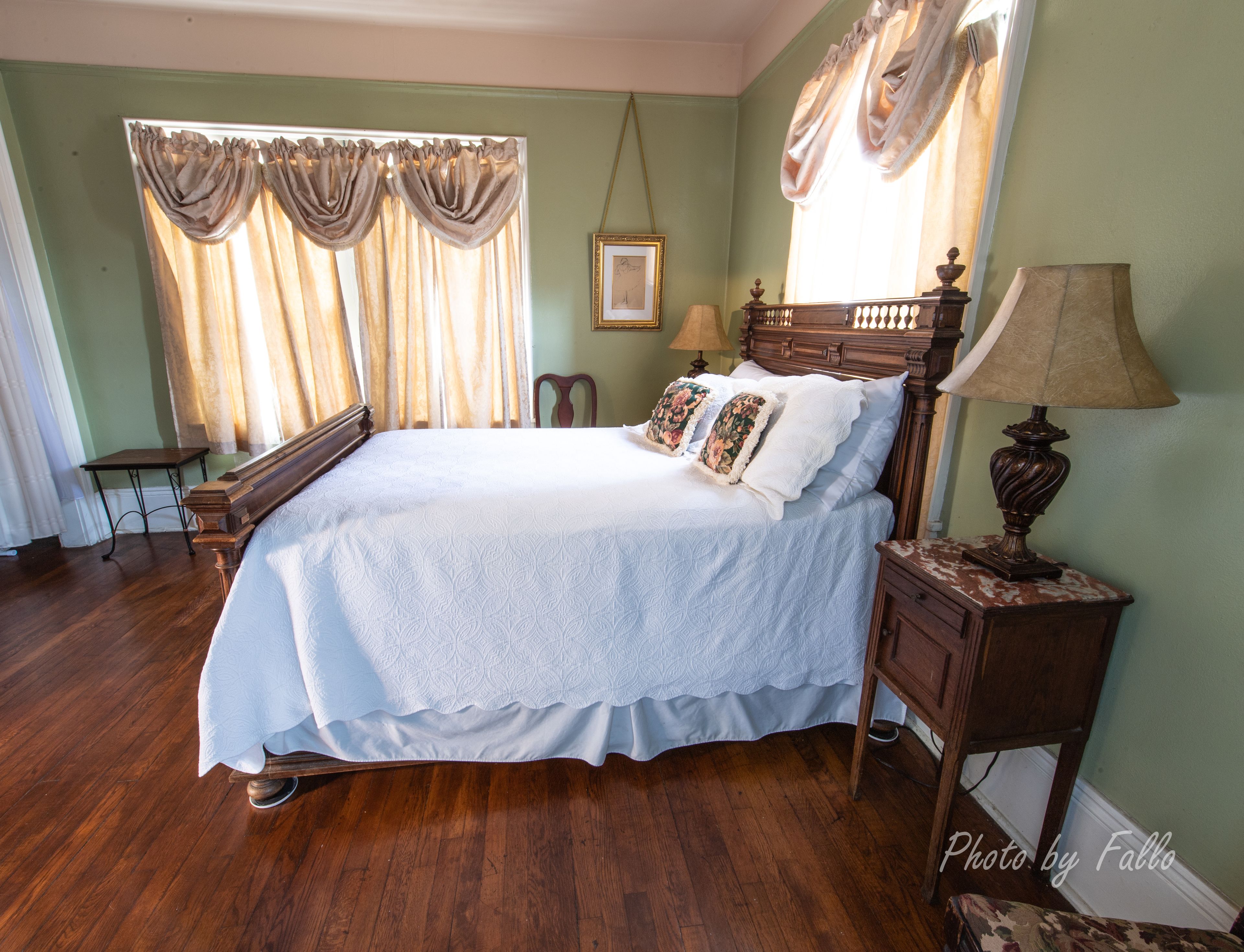 A neatly arranged bedroom with a large bed, a wooden nightstand, a chair, and a table.