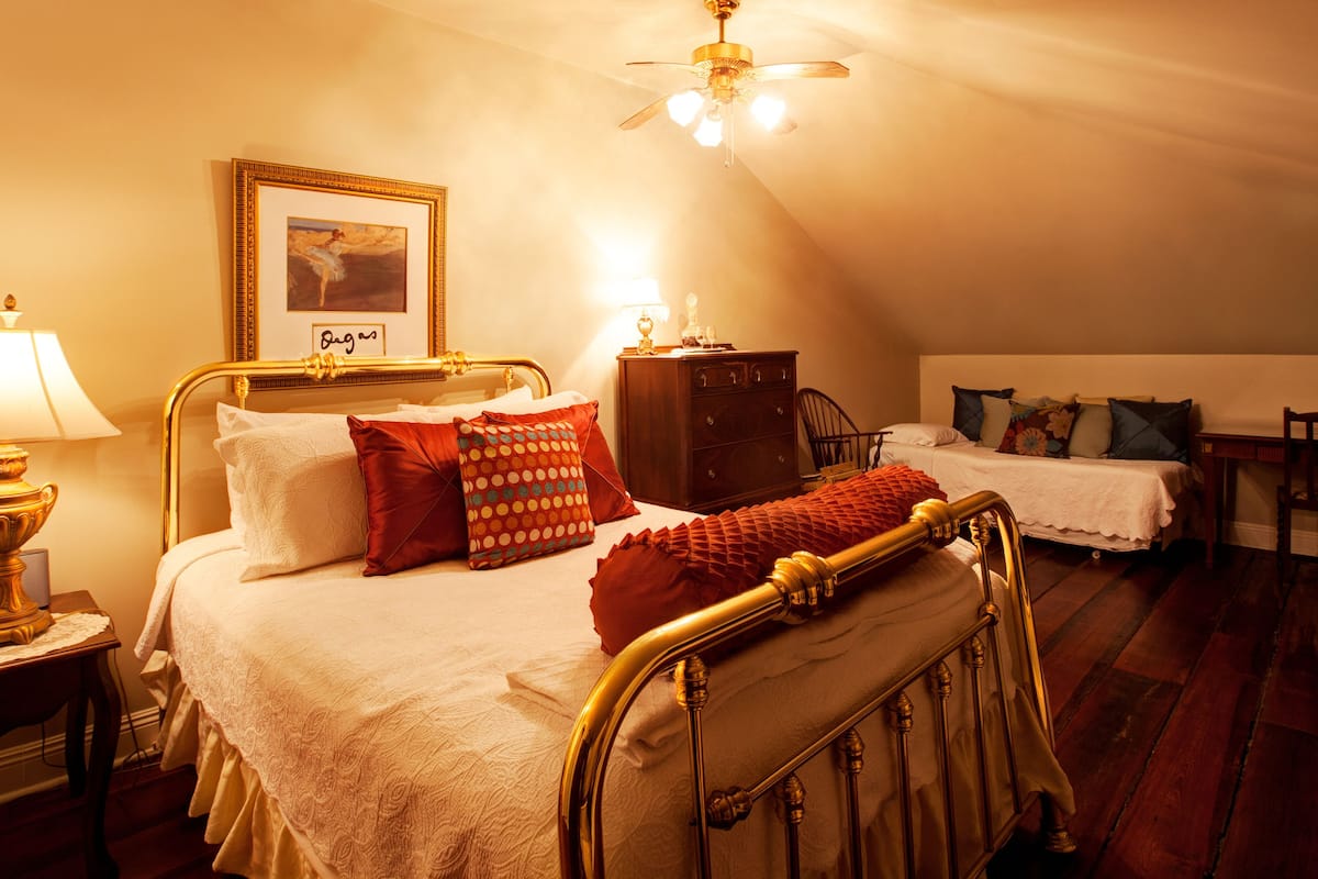 Une chambre confortable avec un lit, une commode, un bureau et une chaise.