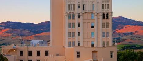 Stunning hotel with a classic central tower and symmetrical windows, set amidst rolling hills.