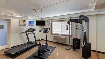 Una palestra con tapis roulant, ellittica e macchina per pesi.