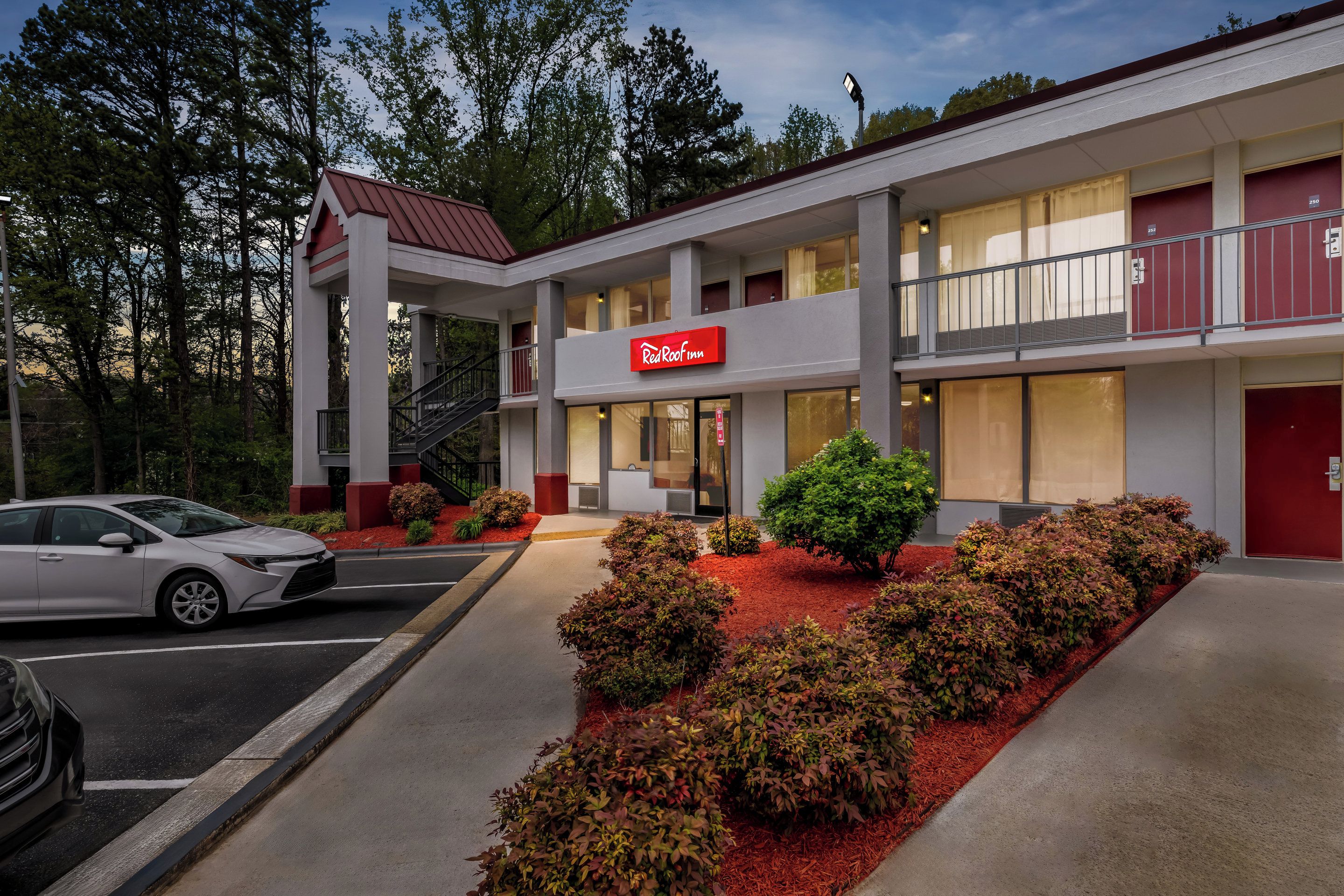 A Red Roof Inn with a two-story structure, a covered outdoor area, and a parking lot.