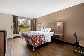 Una habitación de hotel moderna con una cama grande, un escritorio y una silla.