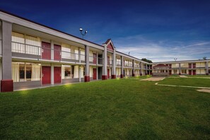 A motel with a central courtyard, multiple floors, and a consistent architectural style.