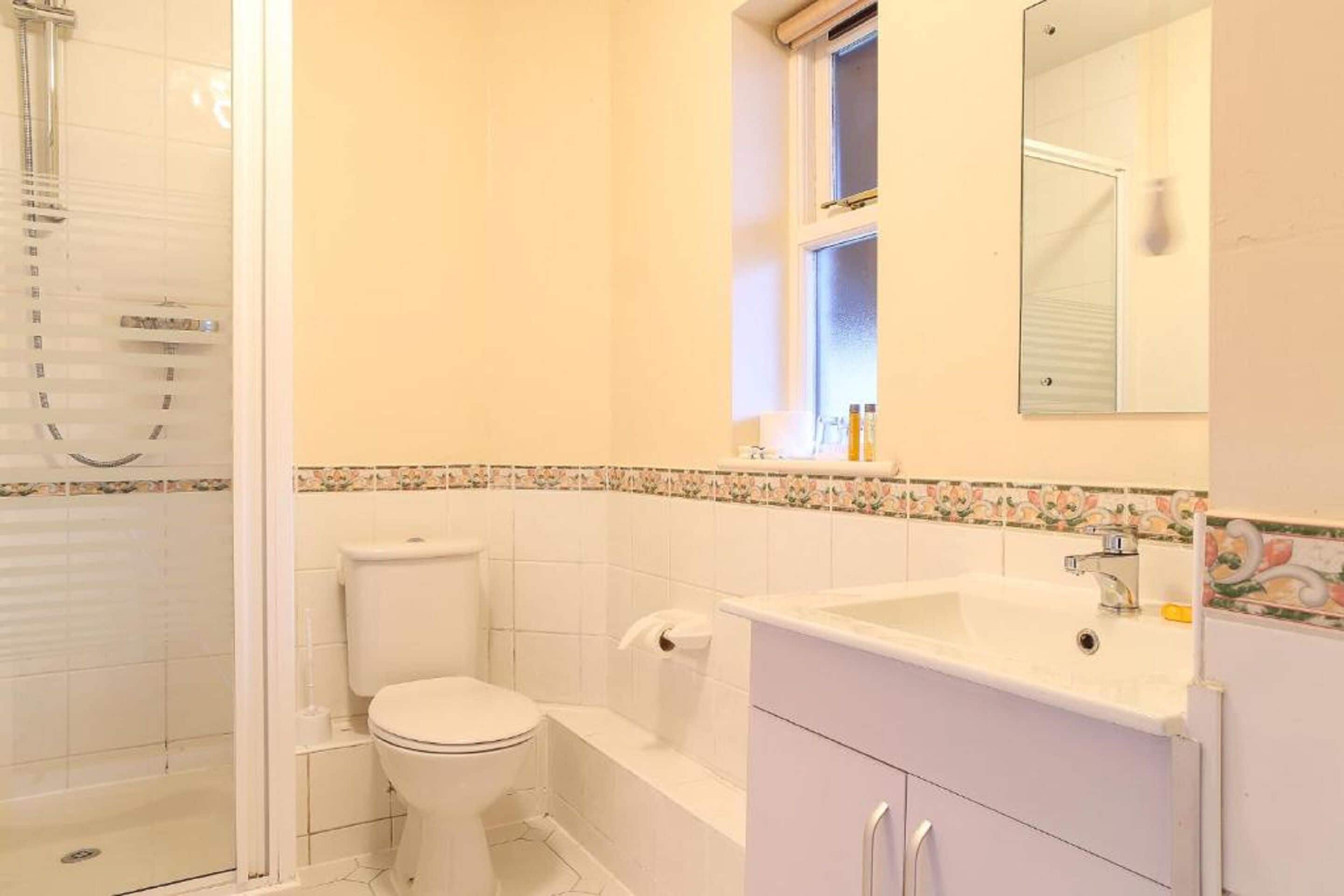 Un baño con inodoro, bañera y cabina de ducha.