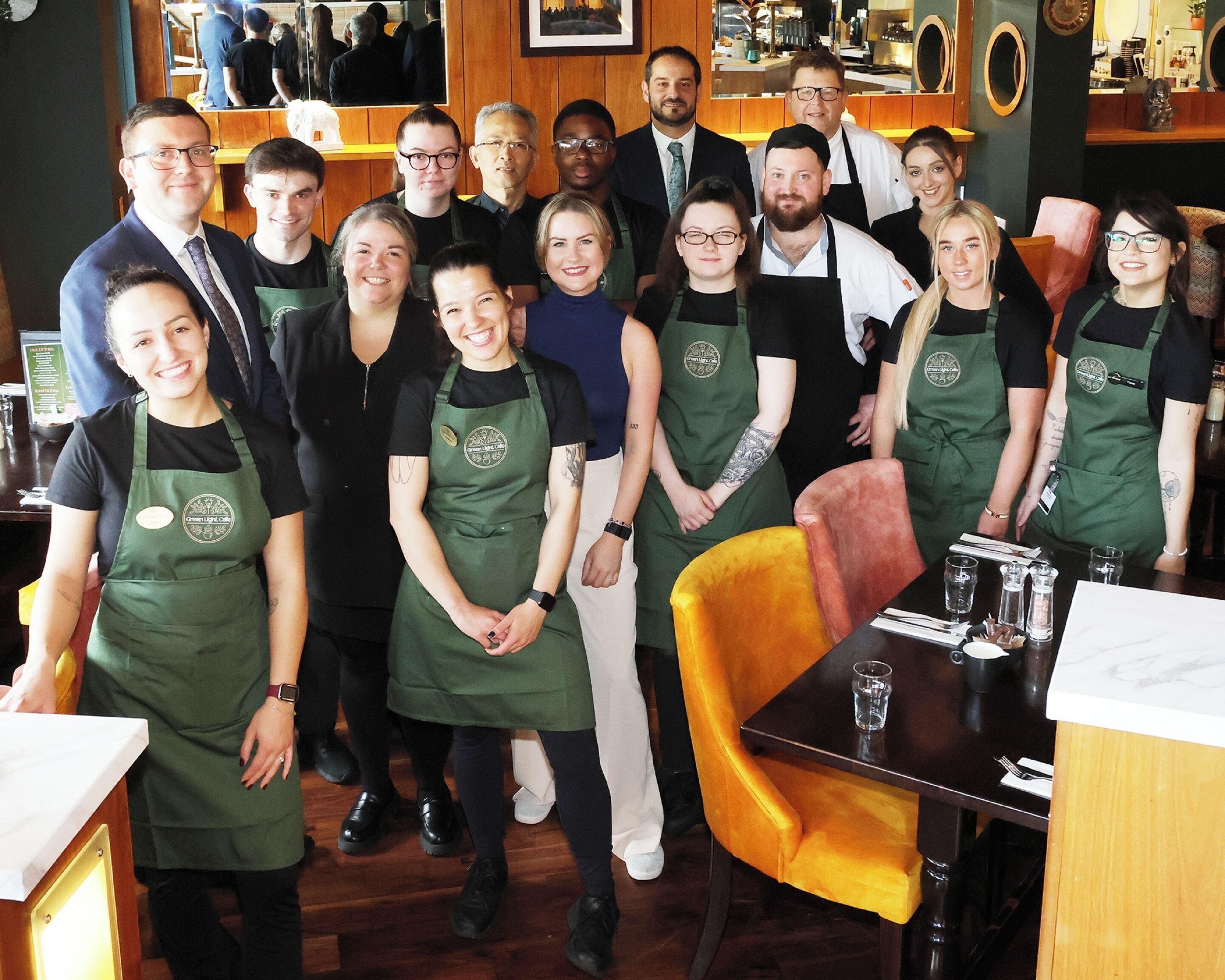 Un grupo de personas en un restaurante con decoración de madera y una zona de bar.