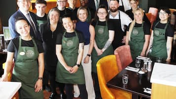 Un grupo de personas en un restaurante con decoración de madera y una zona de bar.