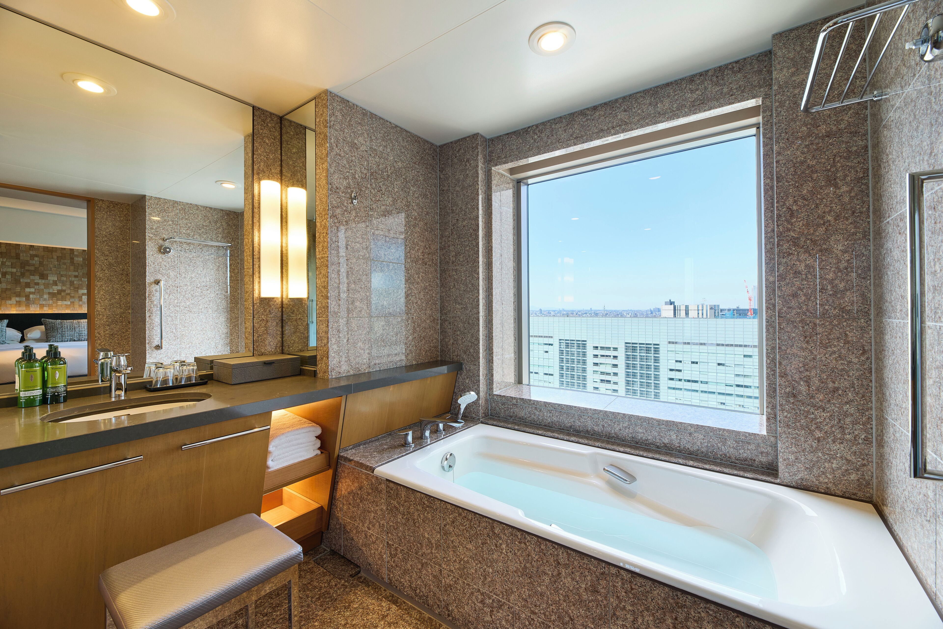 A modern bathroom with a large bathtub, a double sink, and a large mirror.