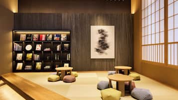 A modern interior with a bookshelf, tatami flooring, and traditional Japanese sliding doors.