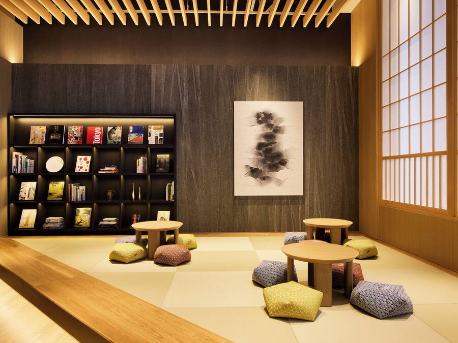 A modern interior with a bookshelf, tatami flooring, and traditional Japanese sliding doors.