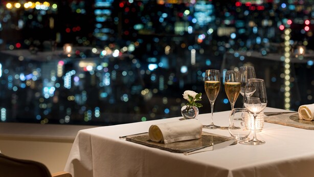 A table set for dining with a cityscape view in the background.