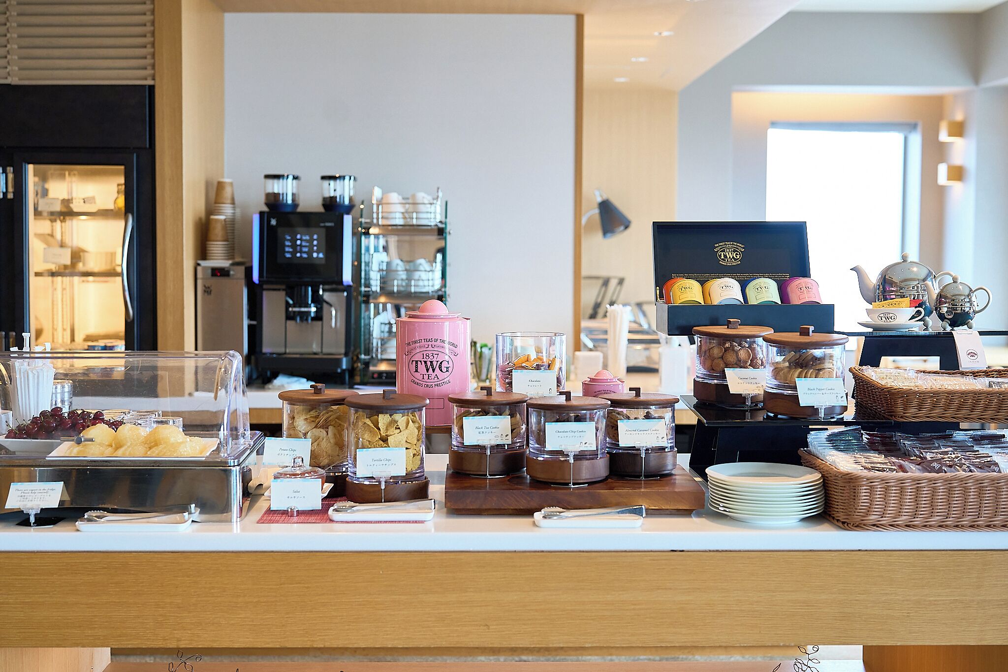 A buffet counter with various food items, a coffee machine, and a tea station.