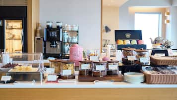 Un mostrador de buffet con diversos alimentos, una máquina de café y una estación de té.