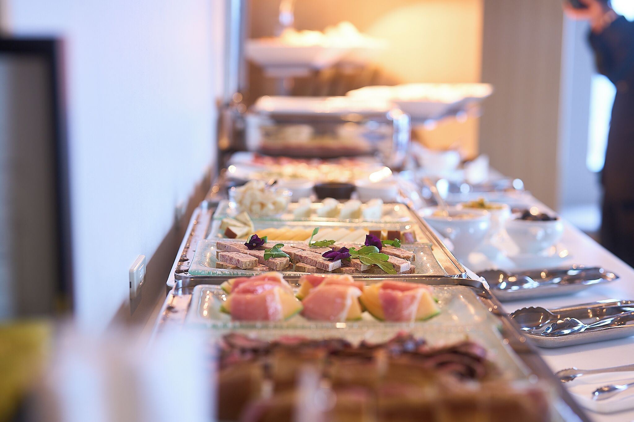 A buffet with various food items and utensils.