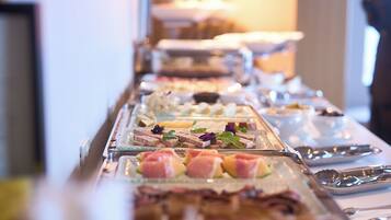 A buffet with various food items and utensils.