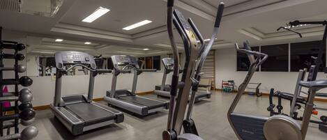 A gym with treadmills, elliptical machines, and weight machines.