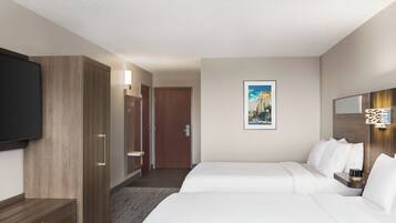 A hotel room with a bed, a TV, a wardrobe, and a bathroom.
