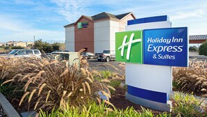 A Holiday Inn Express & Suites sign with a clear view of the hotel building in the background.