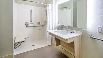 Un baño con ducha, inodoro, lavamanos y espejo.