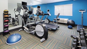 A gym with various exercise equipment including treadmills, an elliptical, and free weights.