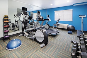 A gym with various exercise equipment including treadmills, an elliptical, and free weights.
