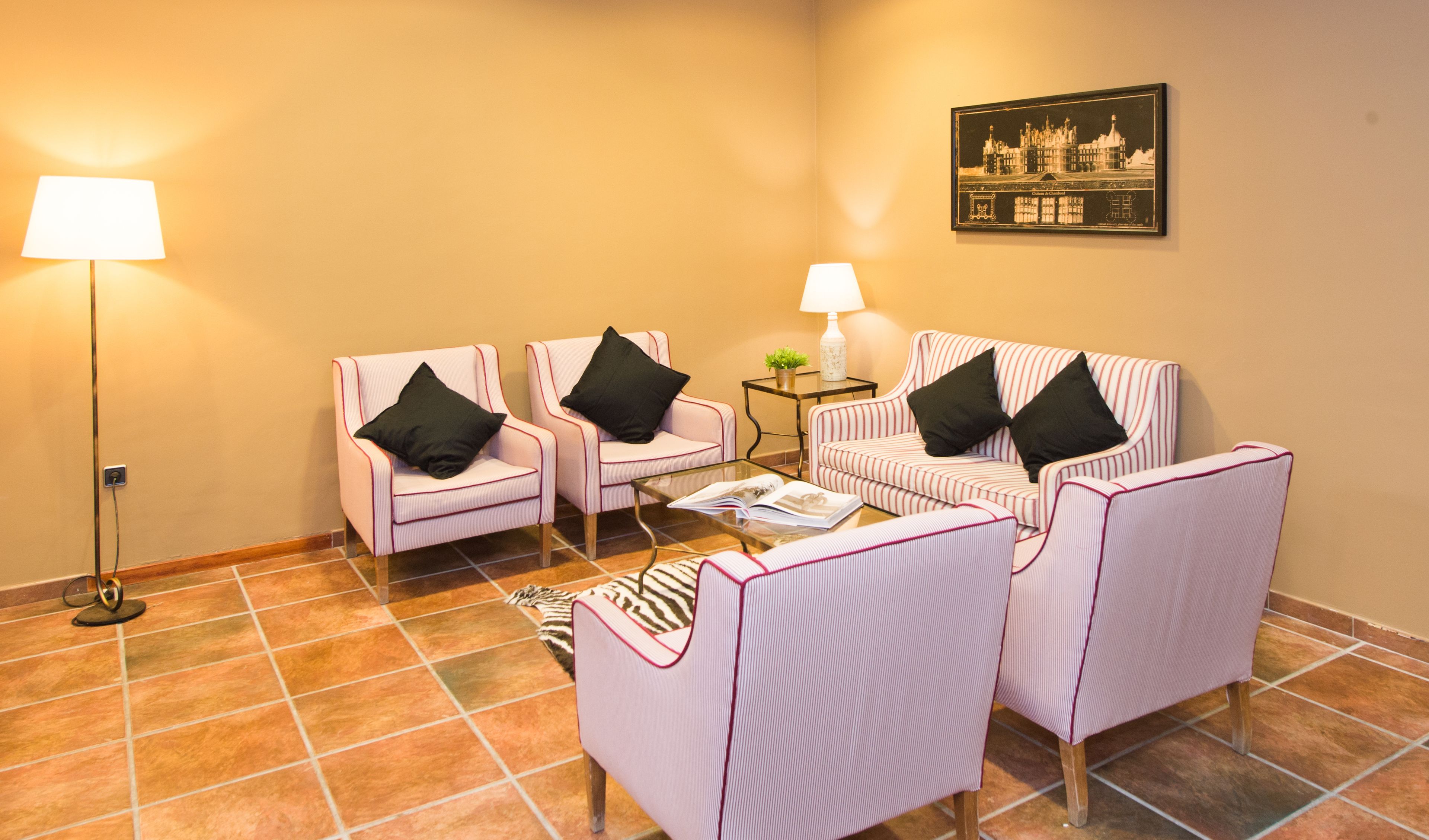 Una habitación con dos sillones, un sofá, una mesita y una lámpara de pie.