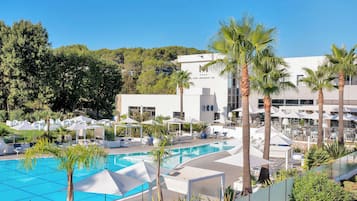 Relax by the pool surrounded by lush greenery and comfortable lounge chairs.
