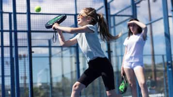 A tennis court with a net and players in action.