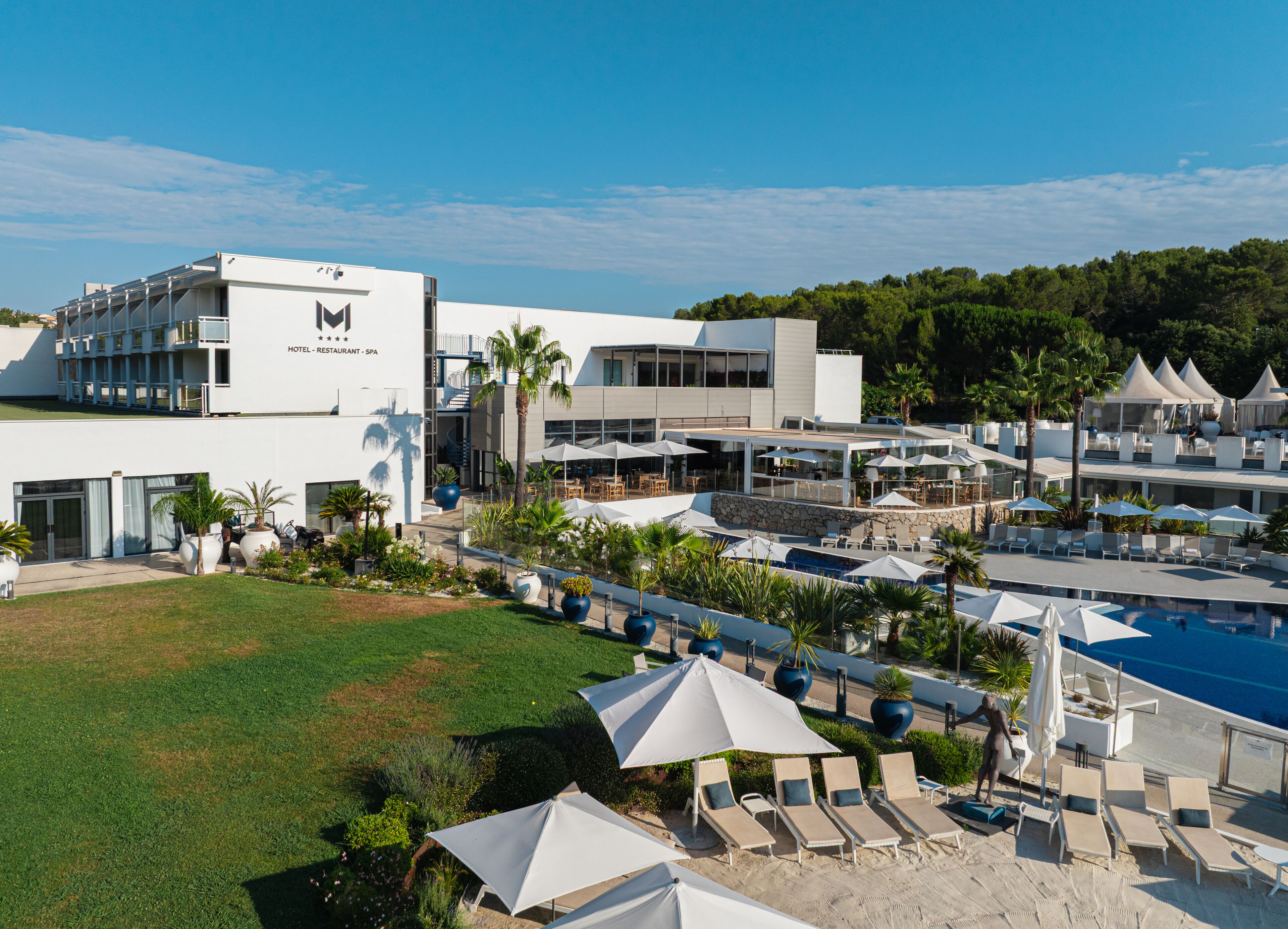 Ein Hotel mit Poolbereich, Außenbereich zum Sitzen und einem modernen Gebäude.