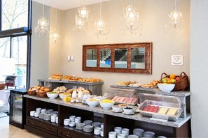 A buffet setup with various food items and a mirror above it. - MR Apart (Santiago)