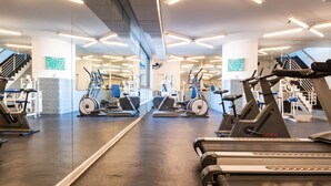 A gym with treadmills, stationary bikes, and weight machines. - MR Apart (Santiago)