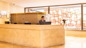 A reception desk with a sign reading "MR. HOTEL" and a modern wall design in the background. - MR Apart (Santiago)