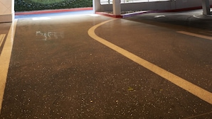 Un intérieur moderne agrémenté d’un panneau « VALET », d’un mur décoré avec le mot « Mahalo » et d’un espace de stationnement propre et bien éclairé.