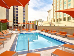 Ein Poolbereich mit Liegestühlen und Sonnenschirmen, ein klares, blaues Schwimmbecken und ein Gebäude mit der Aufschrift 'Las Vegas Club Casino & Hotel'.