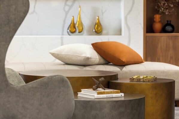 A modern living room with a sofa, two side tables, and decorative items.