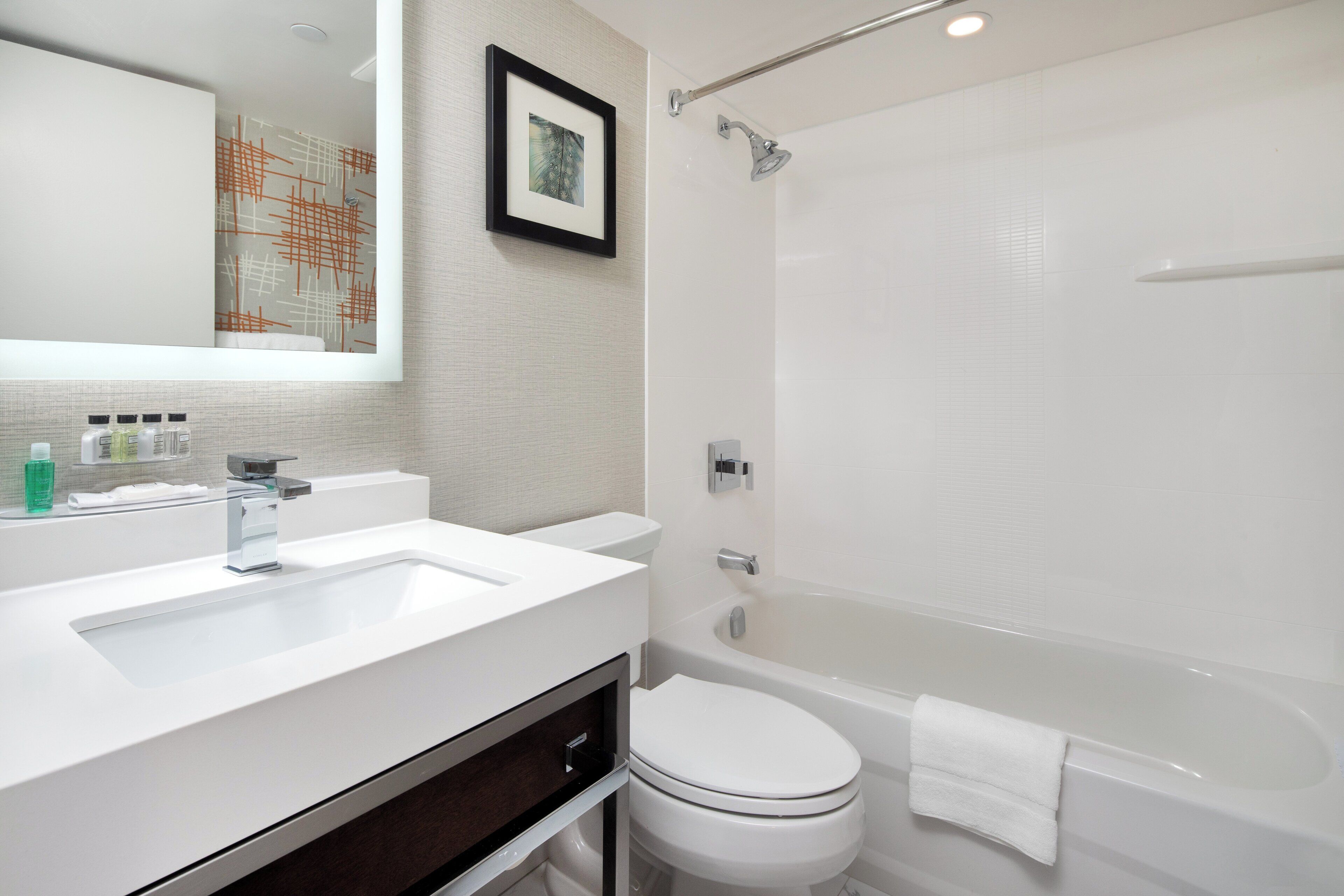 A modern bathroom with a white sink, toilet, and bathtub.