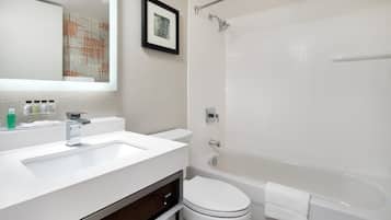 A modern bathroom with a white sink, toilet, and bathtub.