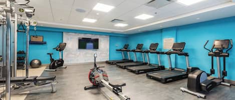 A gym with treadmills, stationary bikes, and weight machines.